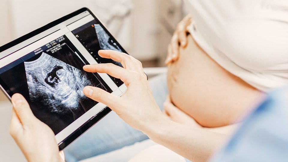 schwangere-frau-ultraschallfoto-auf-tablet-01